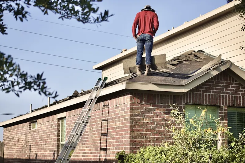 Professional roofer working on a residential roof in Dutch Neck